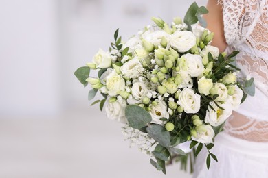 Photo of Bride with beautiful wedding bouquet on light background, closeup. Space for text