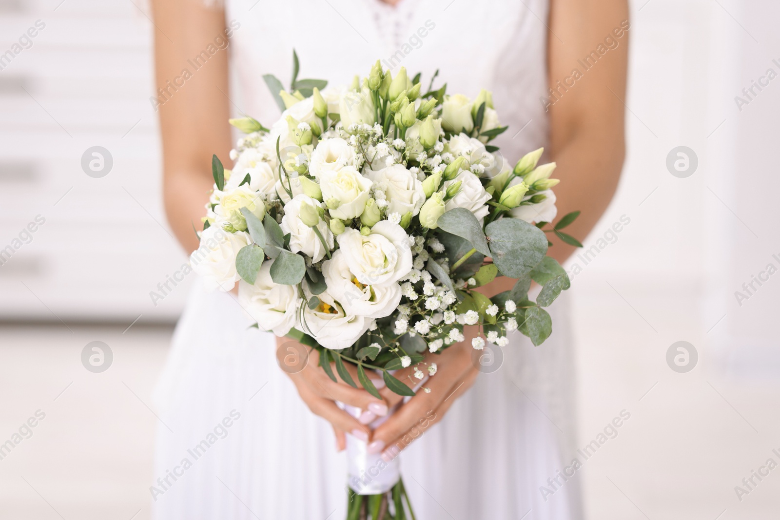 Photo of Bride with beautiful wedding bouquet on light background, closeup