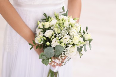 Photo of Bride with beautiful wedding bouquet on light background, closeup