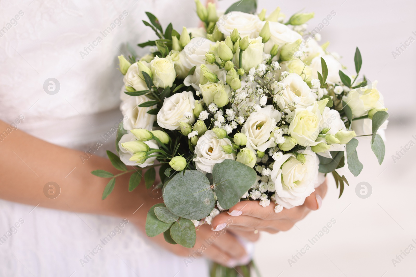 Photo of Bride with beautiful wedding bouquet on light background, closeup