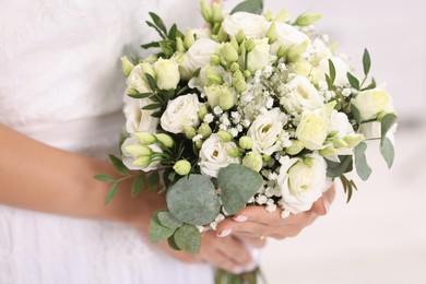 Photo of Bride with beautiful wedding bouquet on light background, closeup