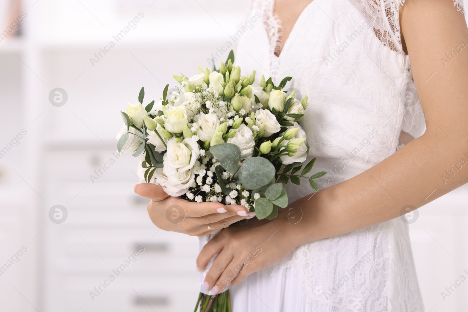 Photo of Bride with beautiful wedding bouquet on light background, closeup. Space for text