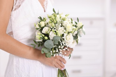 Photo of Bride with beautiful wedding bouquet on light background, closeup. Space for text