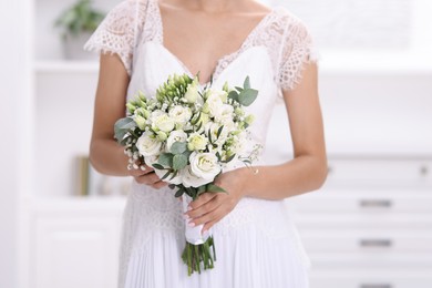 Photo of Bride with beautiful wedding bouquet on light background, closeup