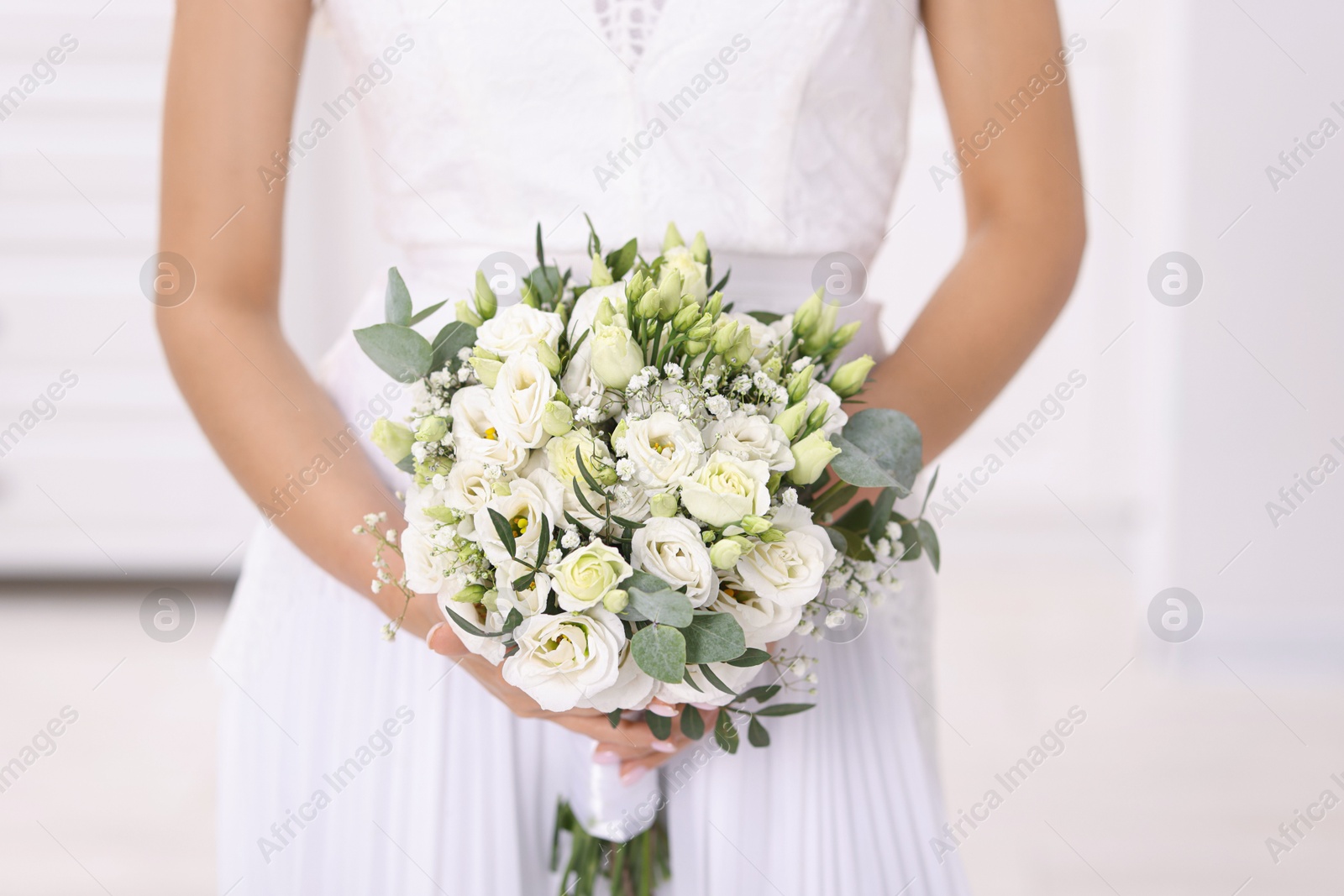 Photo of Bride with beautiful wedding bouquet on light background, closeup