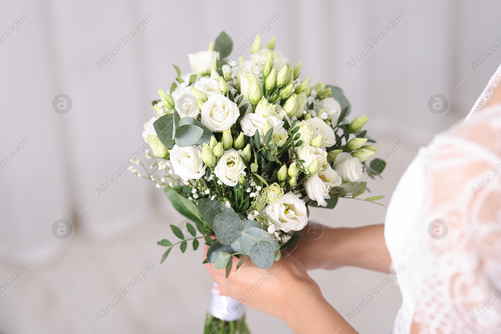 Photo of Bride with beautiful wedding bouquet on light background, closeup. Space for text