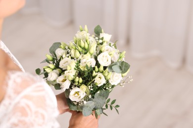 Photo of Bride with beautiful wedding bouquet on light background, closeup. Space for text