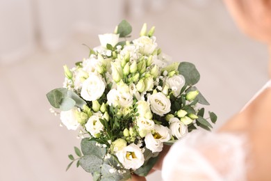 Photo of Bride with beautiful wedding bouquet on light background, closeup