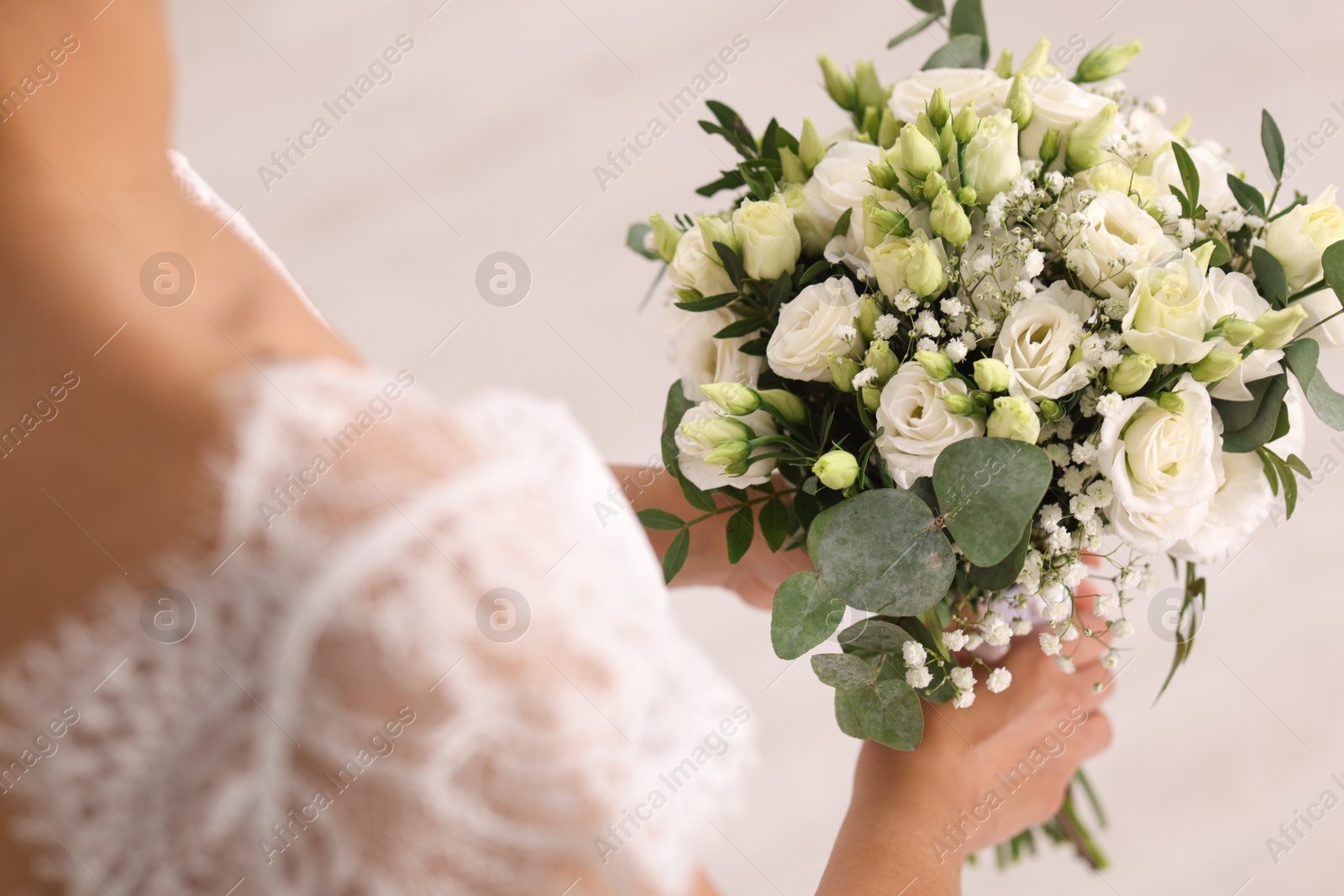 Photo of Bride with beautiful wedding bouquet on light background, closeup