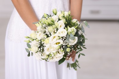 Photo of Bride with beautiful wedding bouquet on light background, closeup. Space for text