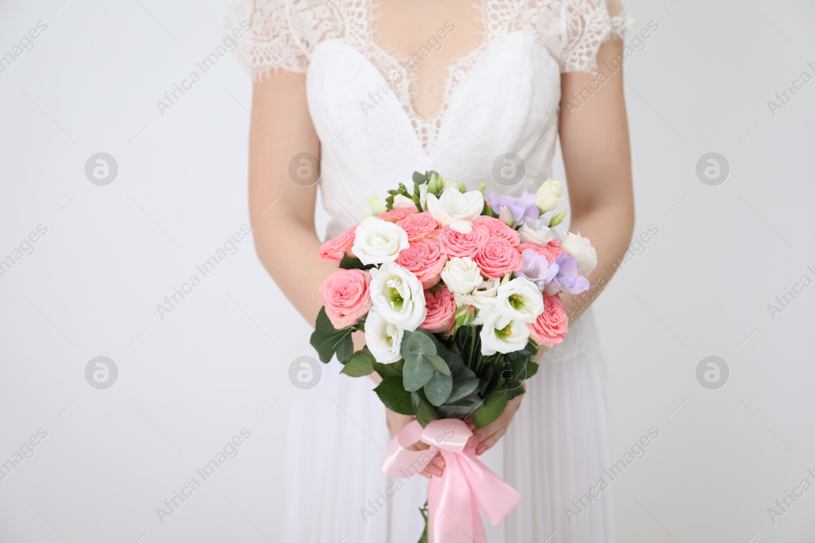 Photo of Bride with beautiful wedding bouquet on light background, closeup