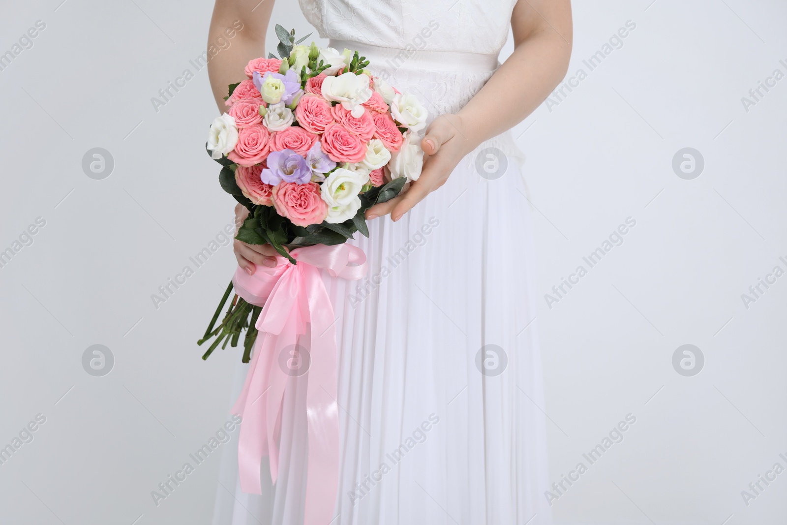 Photo of Bride with beautiful wedding bouquet on light background, closeup