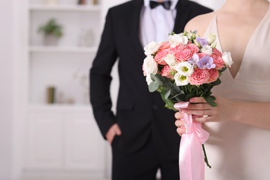 Photo of Bride with beautiful wedding bouquet and groom indoors, closeup. Space for text