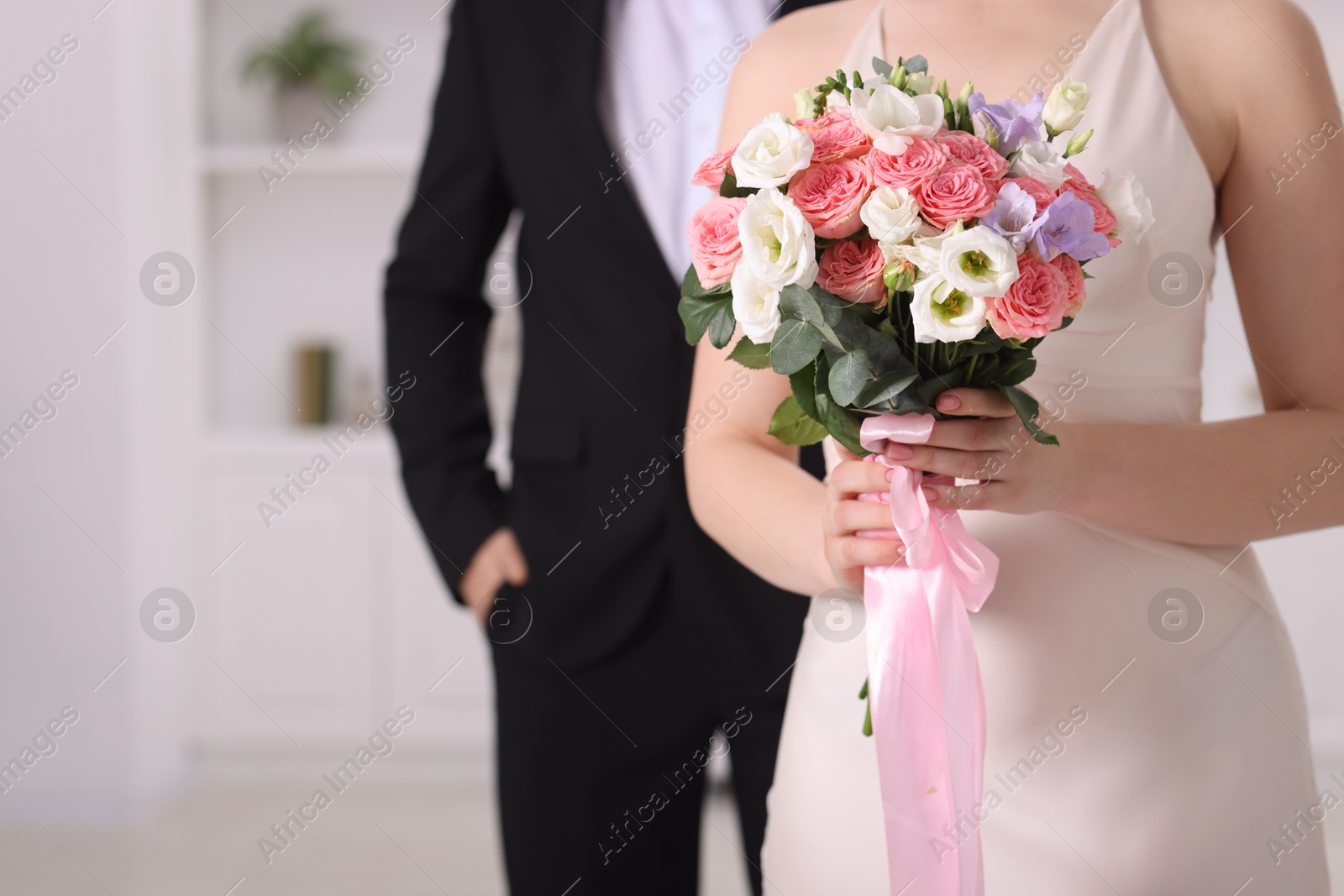 Photo of Bride with beautiful wedding bouquet and groom indoors, closeup. Space for text