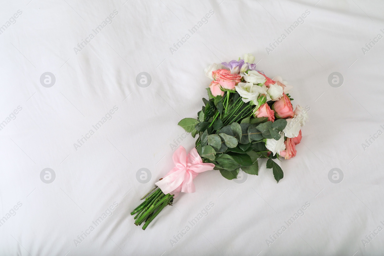 Photo of Wedding bouquet of beautiful flowers on linens, top view. Space for text