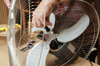 Photo of Relaxing hobby. Senior man repairing fan with screwdriver in workshop, closeup