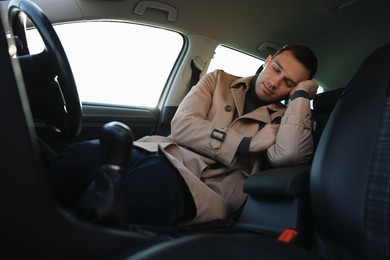 Photo of Tired driver sleeping in his modern car