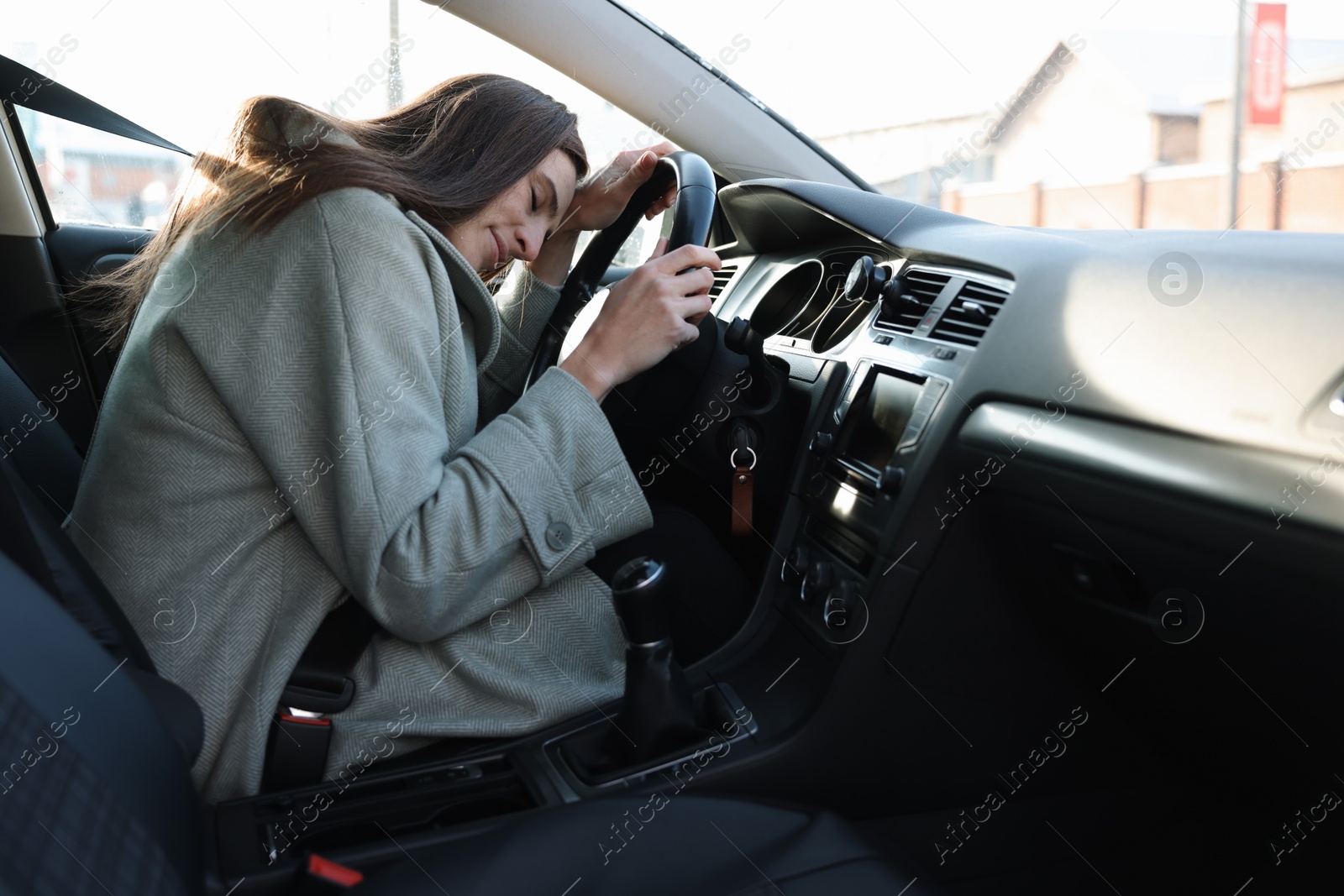 Photo of Tired driver sleeping on steering wheel in car