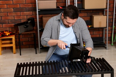 Photo of Relaxing hobby. Man repairing mechanical kitchen scale in workshop