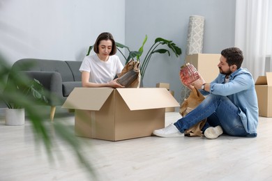 Photo of Moving day. Happy couple unpacking their belongings in new home