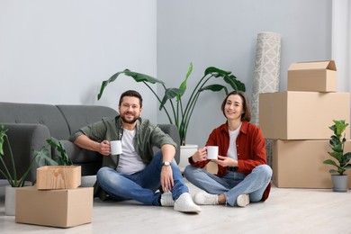 Photo of Moving day. Happy couple with coffee in their new home