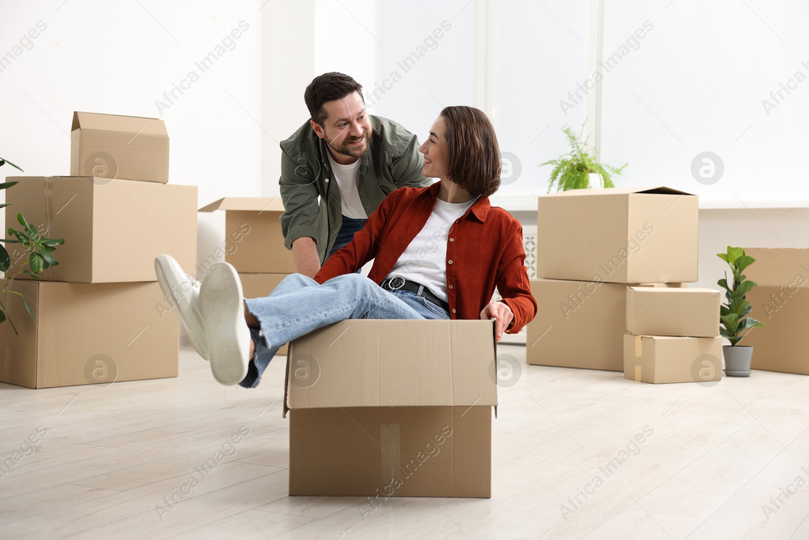 Photo of Moving day. Happy couple having fun in their new home