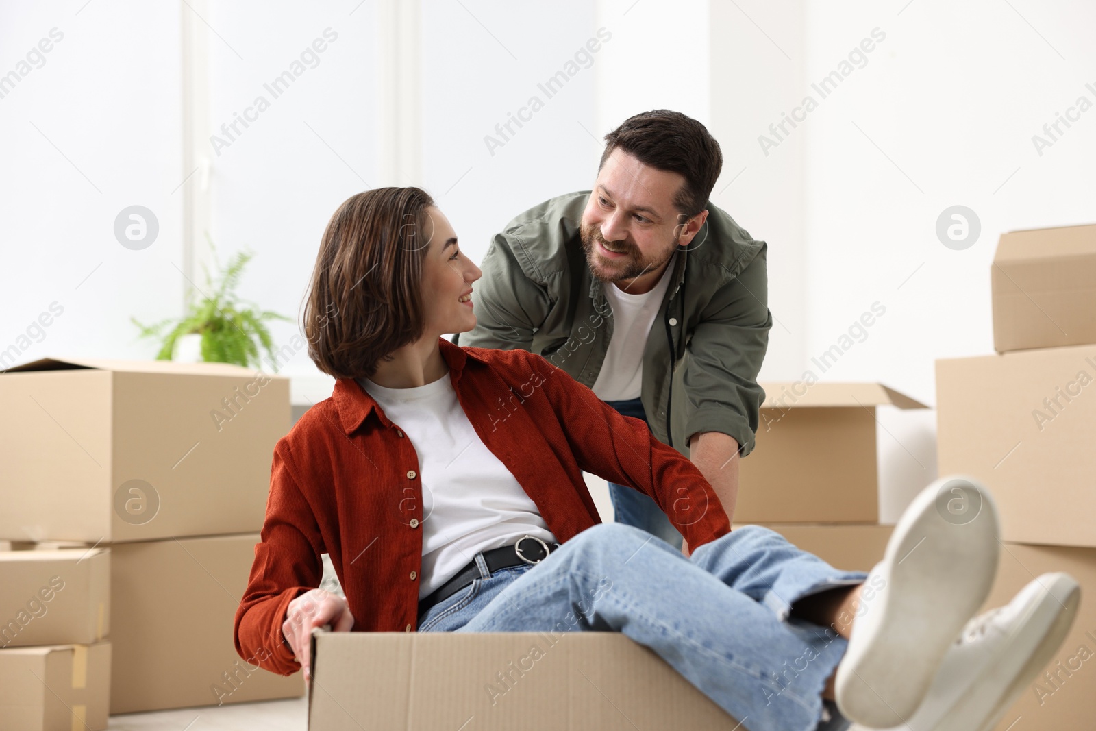 Photo of Moving day. Happy couple having fun in their new home