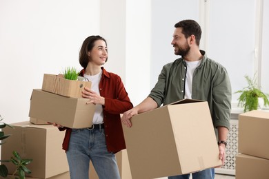 Photo of Moving day. Happy couple with their belongings in new home