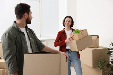 Photo of Moving day. Happy couple with their belongings in new home, selective focus