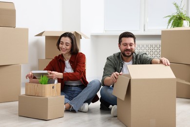 Photo of Moving day. Happy couple unpacking their belongings in new home