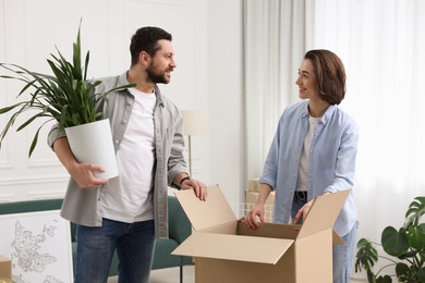 Photo of Moving day. Happy couple unpacking their belongings in new home