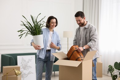 Photo of Moving day. Happy couple unpacking their belongings in new home