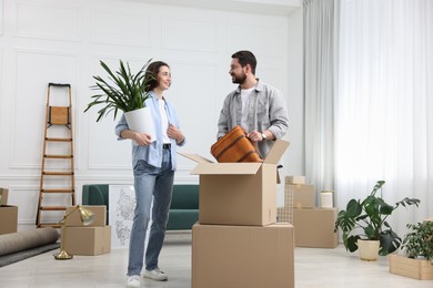 Photo of Moving day. Happy couple unpacking their belongings in new home