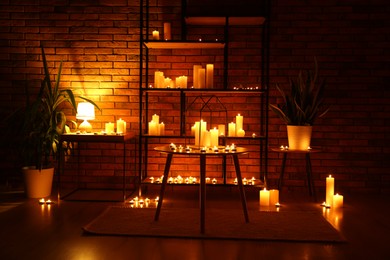 Photo of Many burning paraffin candles in dark room