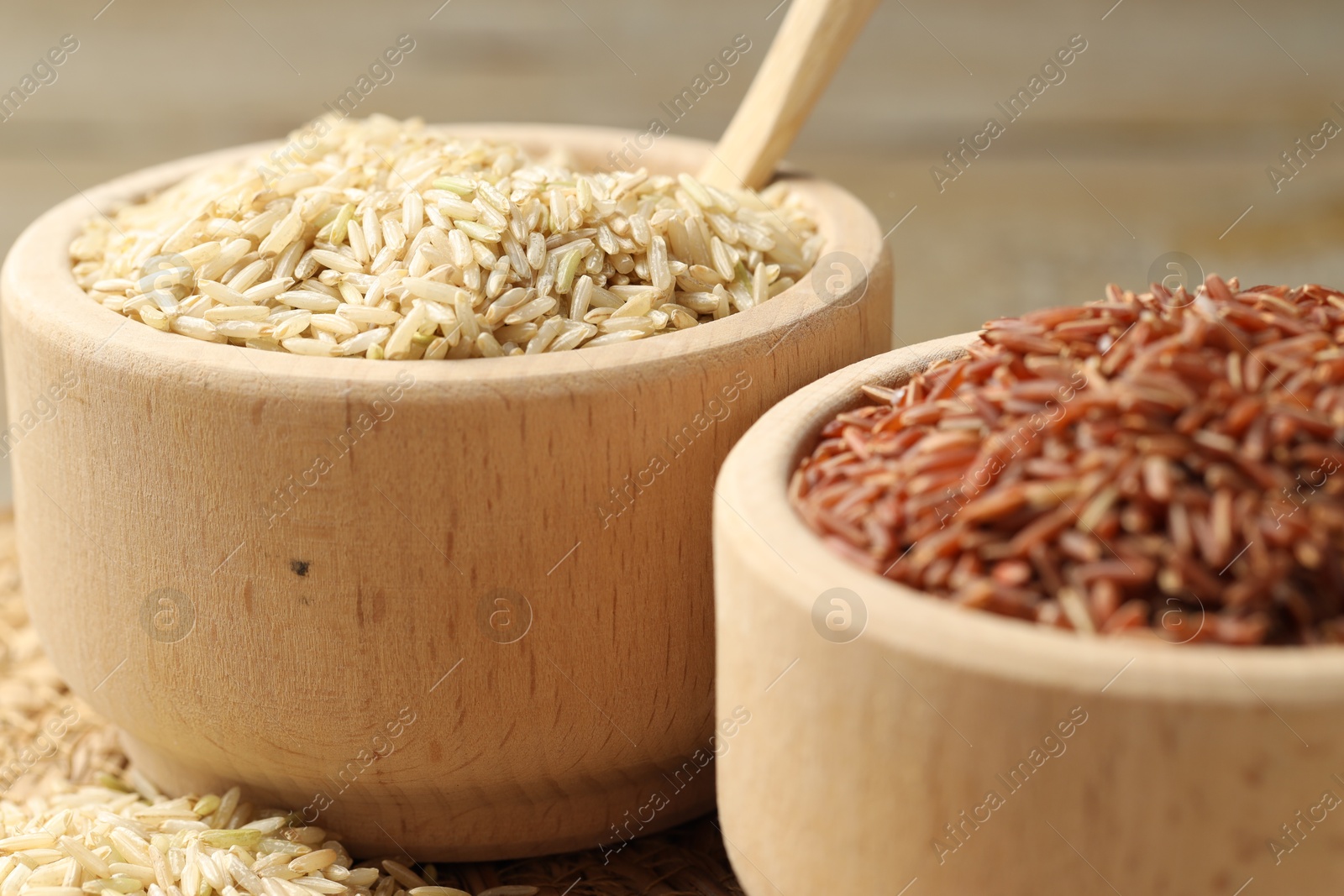 Photo of Different sorts of raw brown rice on table, closeup