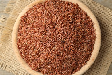 Photo of Raw brown rice in bowl on table, top view