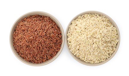 Photo of Different sorts of raw brown rice isolated on white, top view