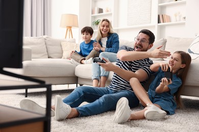 Photo of Happy family playing video games in living room