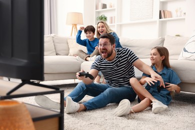 Photo of Happy family playing video games in living room