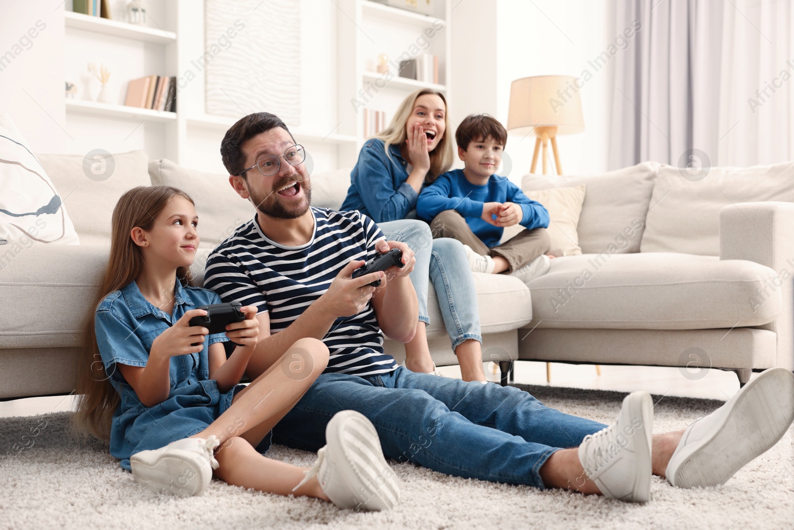 Photo of Happy family playing video games in living room