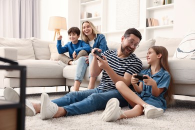 Photo of Happy family playing video games in living room