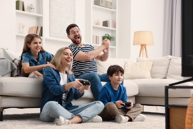 Photo of Happy family playing video games in living room