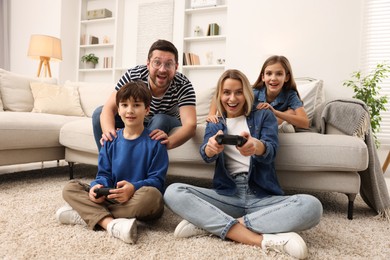 Photo of Happy family playing video games in living room