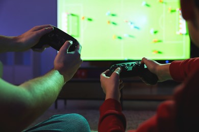 Photo of Father and his son playing video game at home, closeup