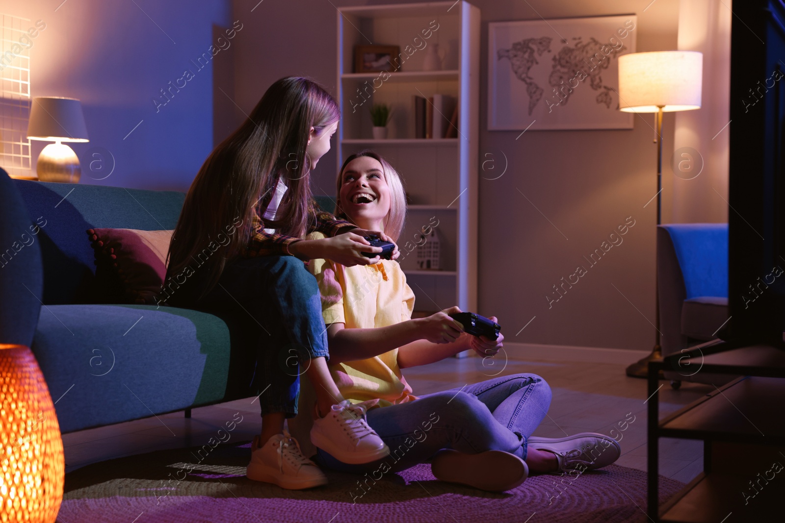 Photo of Happy mother and her daughter playing video games at home