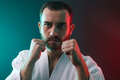 Photo of Karate fighter wearing uniform in color lights