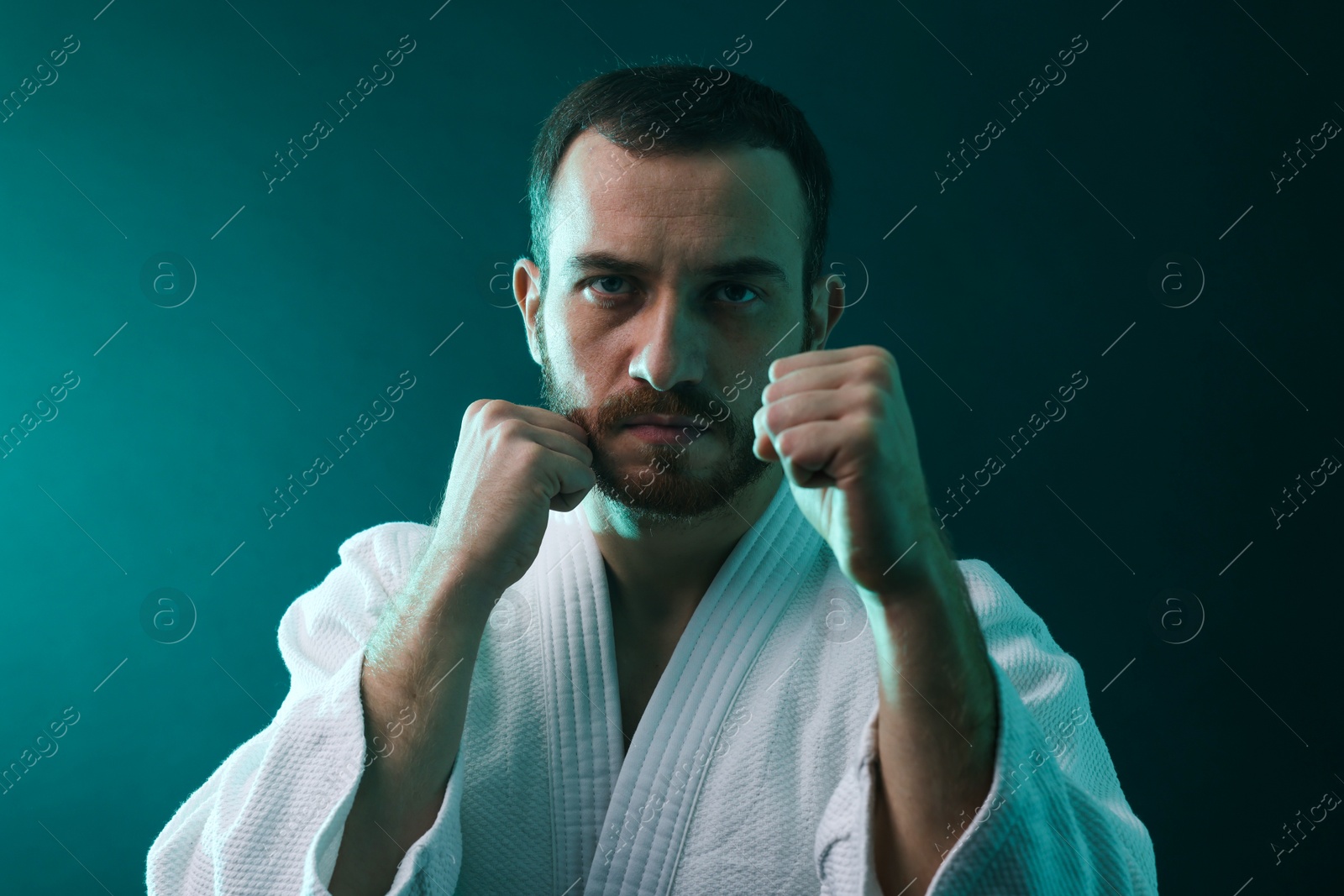 Photo of Karate fighter wearing uniform in color lights