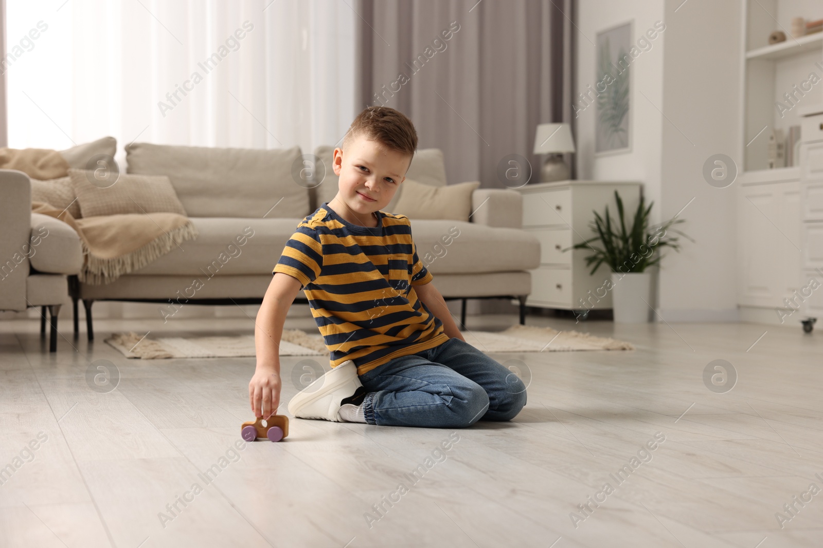 Photo of Little boy playing with toy car at home