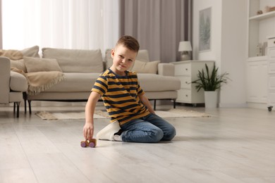 Photo of Little boy playing with toy car at home