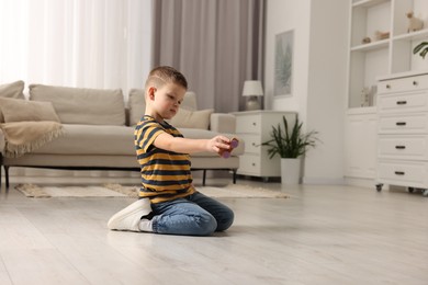 Photo of Little boy playing with toy car at home